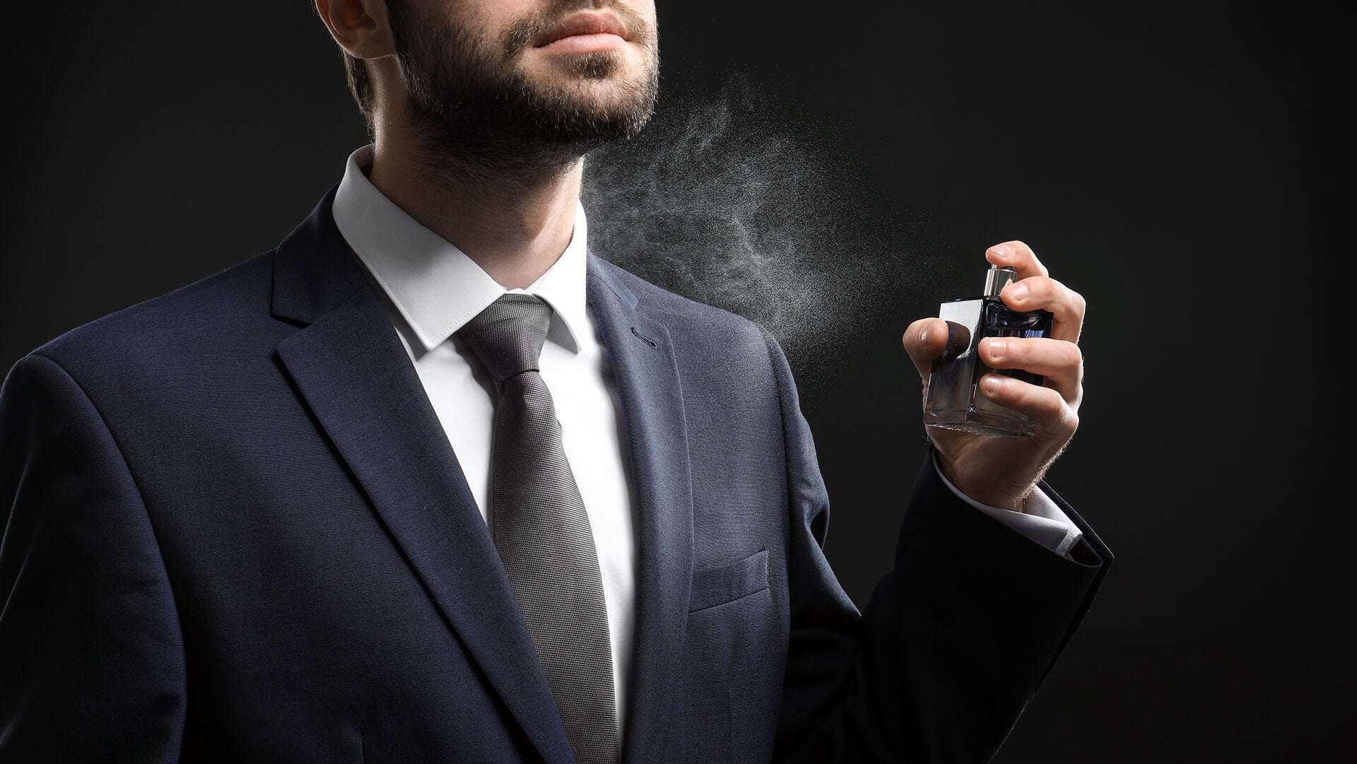 A men spraying a elegant black perfume